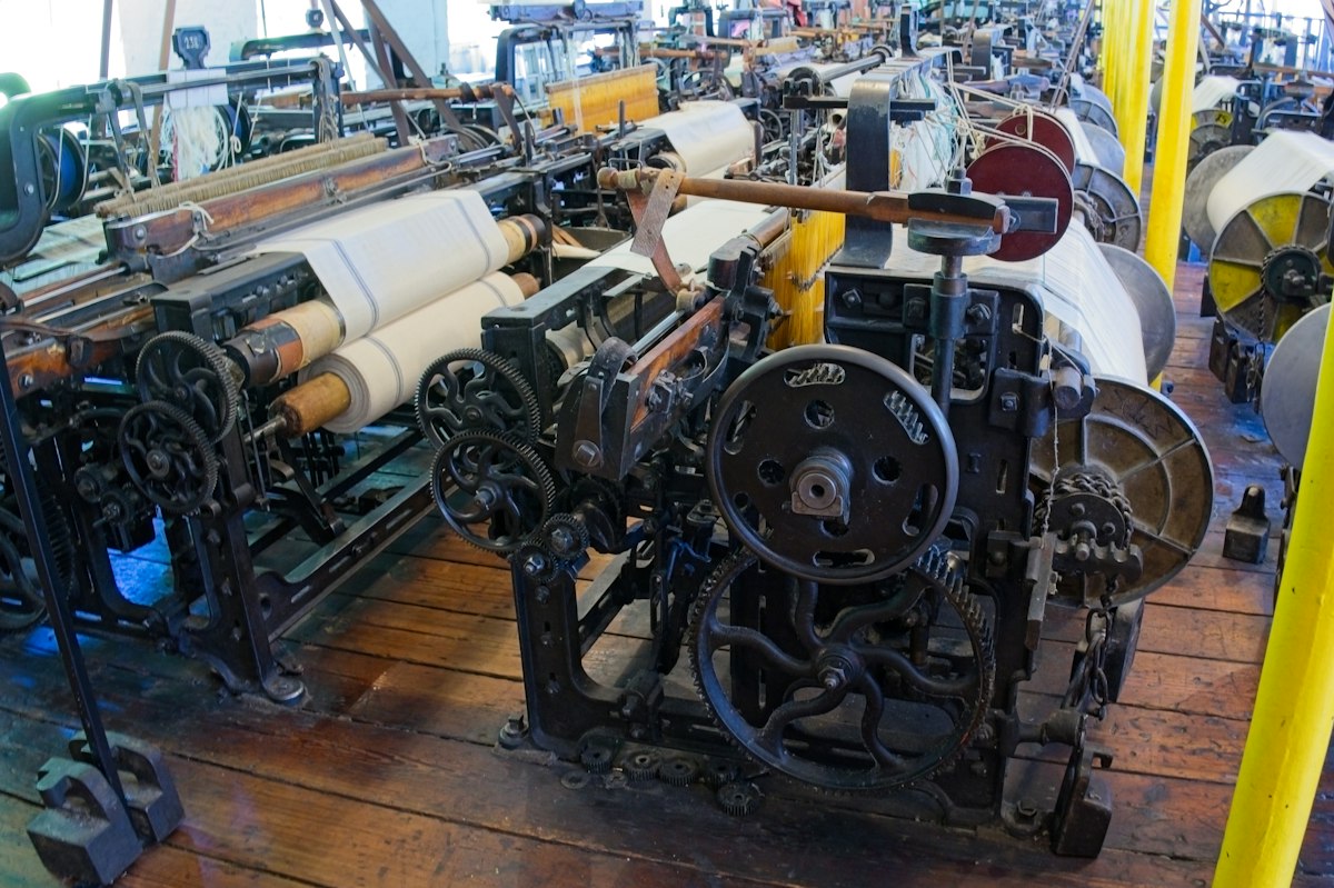 Textile production loom weaving high-density yarn threads